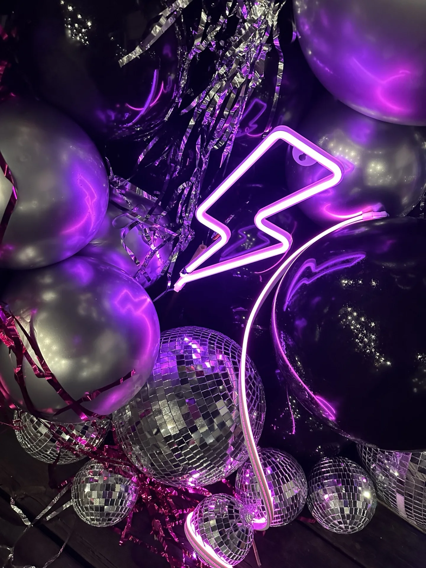 Purple lightning-bolt neon, mirror balls and dark balloons