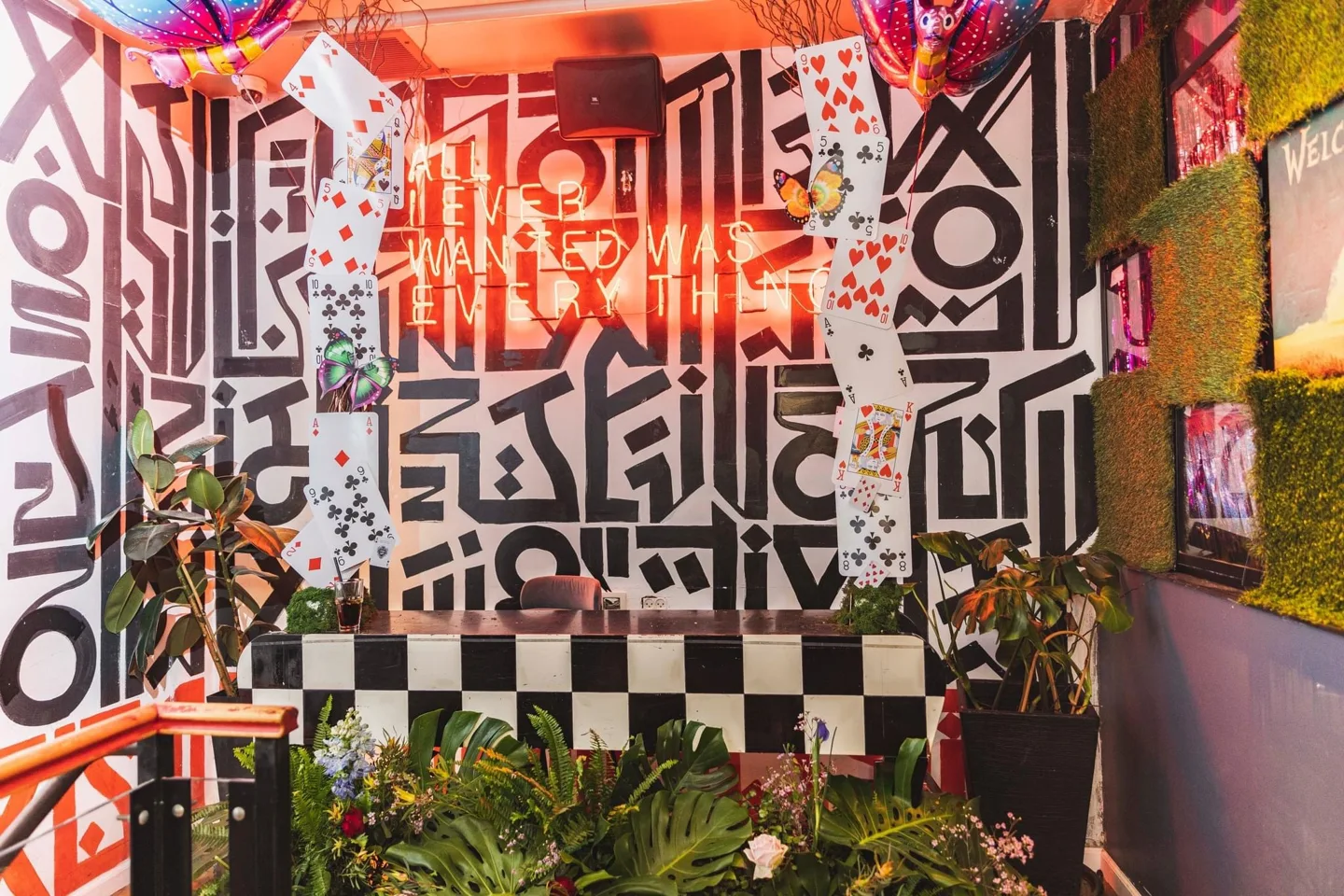 Playing-card backdrop with black-and-white patterns and colourful flowers